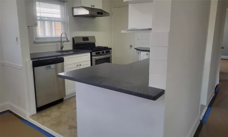 Kitchen featuring kitchen peninsula, stainless steel appliances, white cabinets, and sink