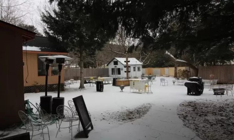 Snowy yard featuring an outbuilding and a fire pit