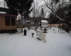 Yard layered in snow with an outbuilding