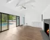 Unfurnished living room featuring ceiling fan, hardwood / wood-style floors, high vaulted ceiling, and beamed ceiling