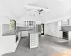 Kitchen with wall chimney exhaust hood, beam ceiling, white cabinets, and a center island