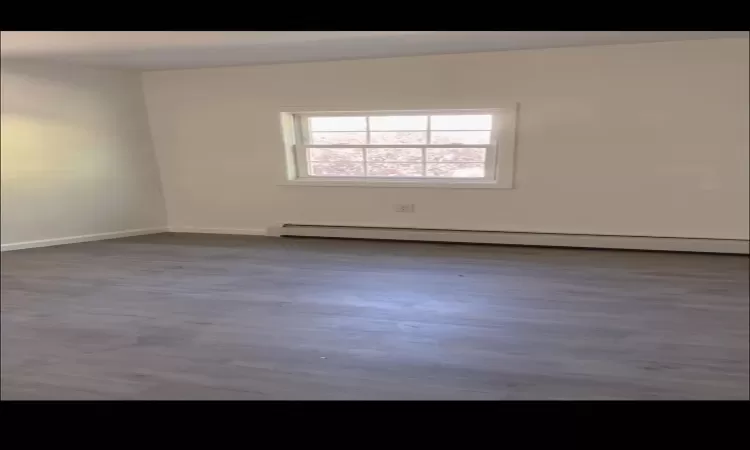 Empty room with a baseboard heating unit