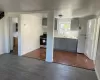 Kitchen featuring dark wood-type flooring, white fridge, stainless steel gas stove, sink, and gray cabinetry