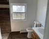 Bathroom with a shower, baseboard heating, toilet, and vanity