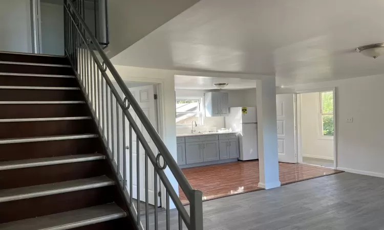 Staircase featuring wood-type flooring and sink