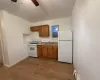 Kitchen featuring ceiling fan, sink, light hardwood / wood-style floors, and white appliances