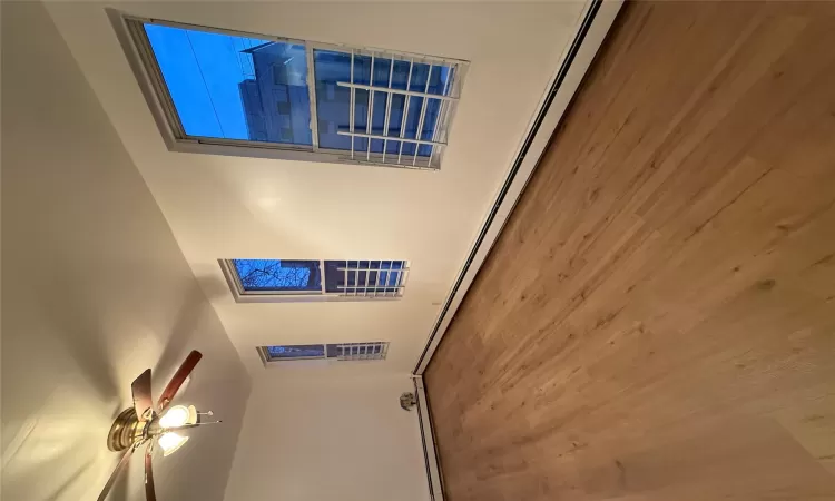 Empty room featuring ceiling fan, baseboard heating, and hardwood / wood-style floors