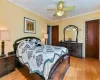 Bedroom featuring light wood-type flooring, ceiling fan, and crown molding