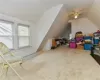 Additional living space with ceiling fan, carpet flooring, and vaulted ceiling