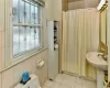 Bathroom featuring toilet, a shower with shower curtain, tile patterned floors, and sink