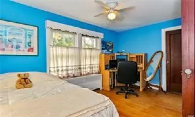 Bedroom with ceiling fan and wood-type flooring