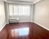 Empty room featuring dark hardwood / wood-style floors, a healthy amount of sunlight, and a wall mounted air conditioner