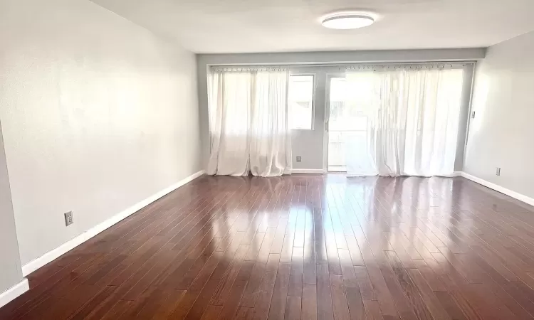 Spare room featuring dark wood-type flooring