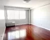 Spare room with a wealth of natural light, a wall mounted AC, and dark hardwood / wood-style flooring