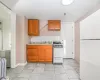 Kitchen with white appliances, tasteful backsplash, light tile patterned flooring, and sink