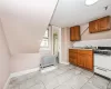 Kitchen featuring radiator, light tile patterned floors, white range with gas cooktop, tasteful backsplash, and sink