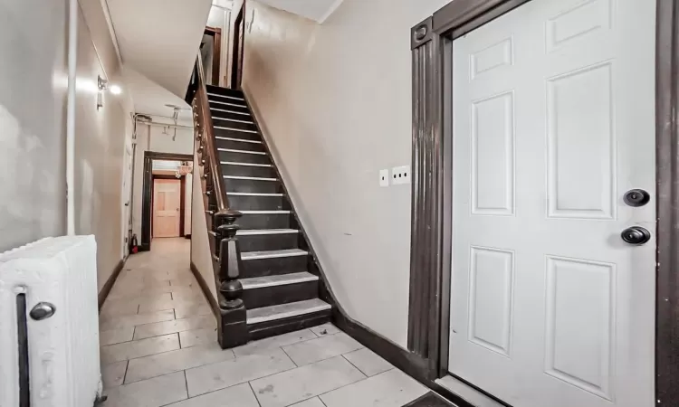 Staircase with tile patterned flooring and radiator