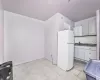 Kitchen featuring sink, white fridge, backsplash, and light tile patterned floors