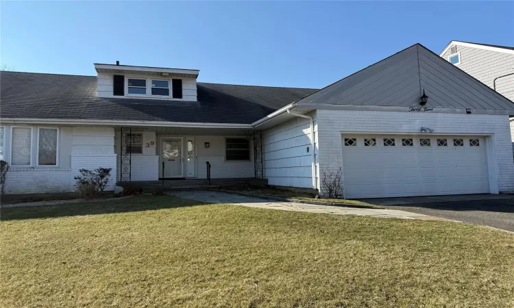 View of front of house featuring a garage and a front yard