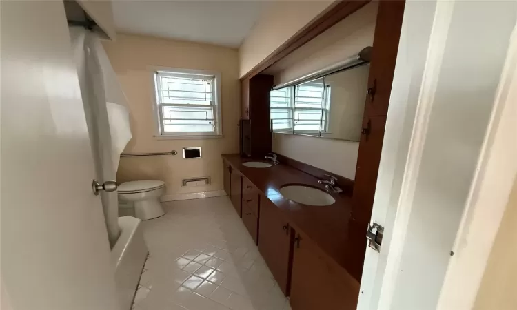 Bathroom with tile patterned floors, vanity, and toilet