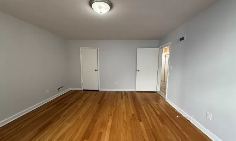 Unfurnished bedroom featuring hardwood / wood-style flooring