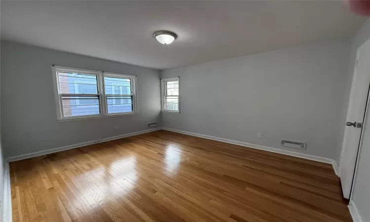 Empty room with hardwood / wood-style flooring