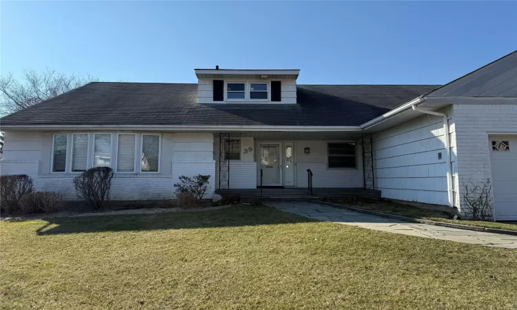 View of front of house with a garage and a front lawn