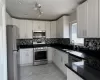 Kitchen with appliances with stainless steel finishes, white cabinetry, tasteful backsplash, and sink