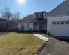 View of front of property with a garage and a front lawn