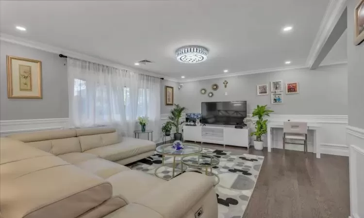 Living room featuring wood-type flooring and ornamental molding