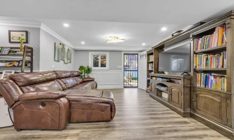 Living room with light hardwood / wood-style floors and ornamental molding