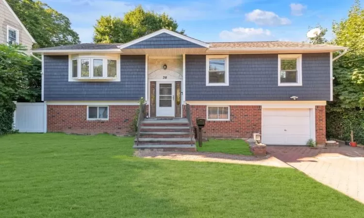 Split foyer home with a front yard and a garage