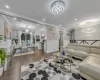 Living room featuring dark wood-type flooring, crown molding, and a notable chandelier