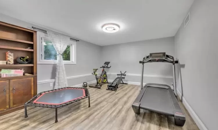 Exercise area with light hardwood / wood-style floors