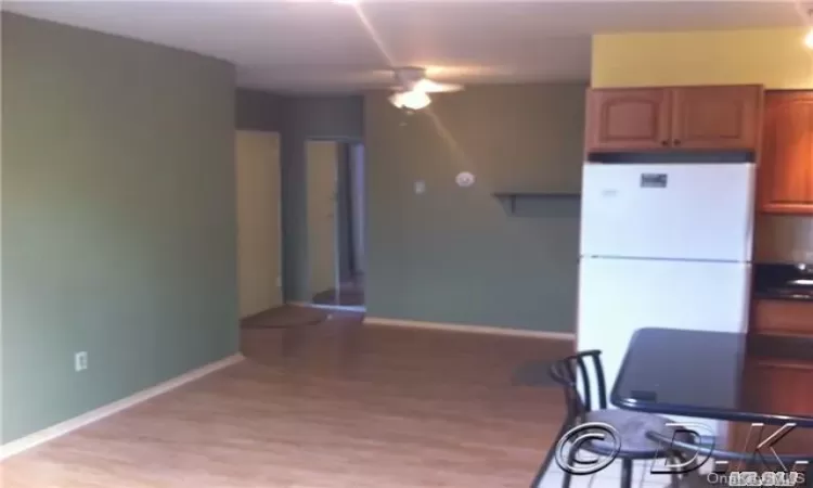 Kitchen featuring ceiling fan, white fridge, and light hardwood / wood-style flooring