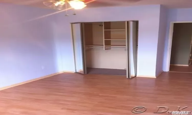 Unfurnished bedroom with ceiling fan, a closet, and hardwood / wood-style flooring