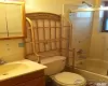 Full bathroom featuring toilet, vanity, and shower / bath combination with glass door