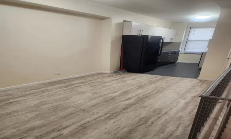 Kitchen with black fridge and white cabinetry