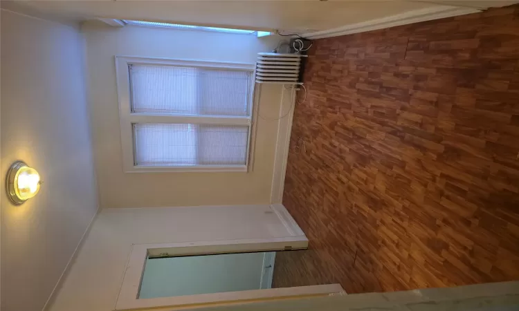 Empty room with dark hardwood / wood-style floors and radiator