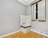 Bathroom featuring a baseboard heating unit, parquet floors, and ornamental molding