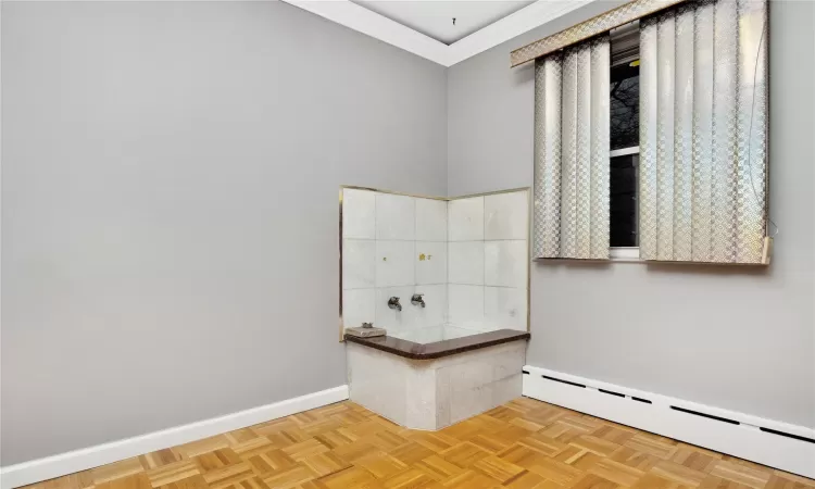 Bathroom featuring a baseboard heating unit, parquet floors, and ornamental molding