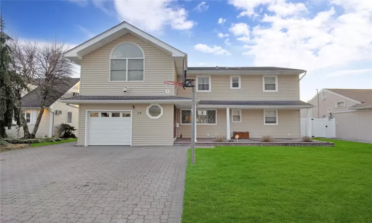 View of front of property with a front yard and a garage