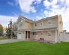 View of front of property featuring a front lawn and a garage