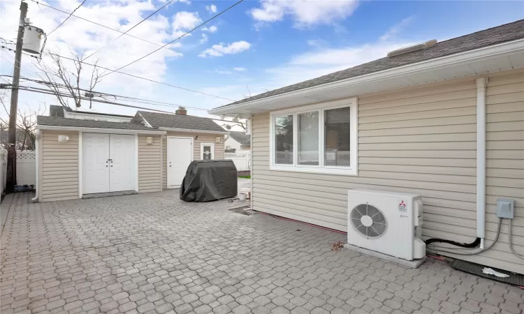 View of patio featuring an outdoor structure, a grill, and ac unit