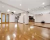 Unfurnished living room featuring ceiling fan, an AC wall unit, light hardwood / wood-style flooring, radiator, and french doors