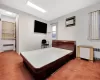 Carpeted bedroom featuring radiator heating unit and a wall unit AC