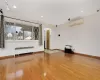 Empty room with radiator, wood-type flooring, and a wall mounted air conditioner