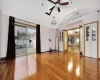 Spare room featuring ceiling fan, vaulted ceiling with skylight, hardwood / wood-style floors, and a baseboard heating unit