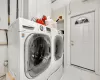 Laundry room featuring light tile patterned flooring and washing machine and clothes dryer