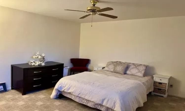 Bedroom featuring ceiling fan, wall to wall carpet (hardwood under); and large closet.